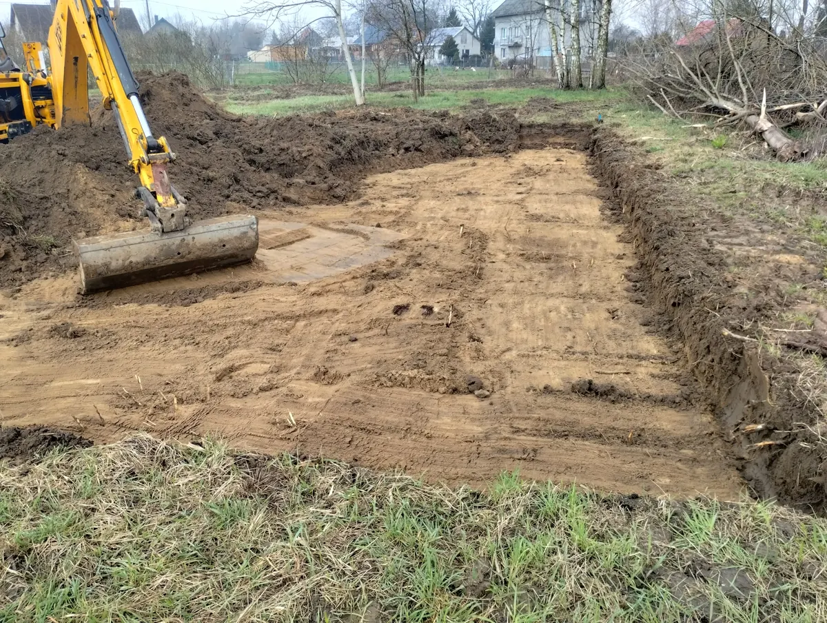Koparka usuwa warstwę nienośną gruntu pod płytę fundamentową – realizacja PB DOMY